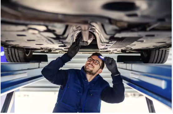 Technician inspecting a vehicle underbody on a lift